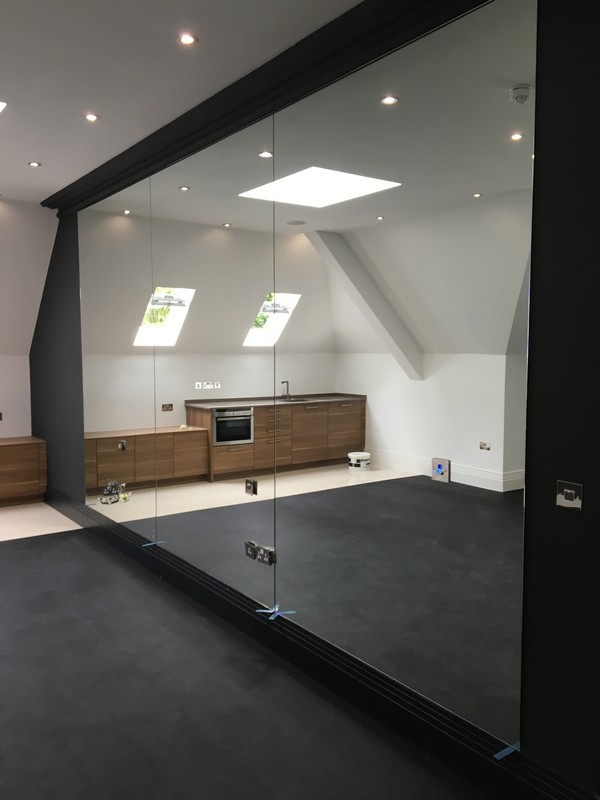 Frameless glass partition in loft conversion by Crouch End glaziers